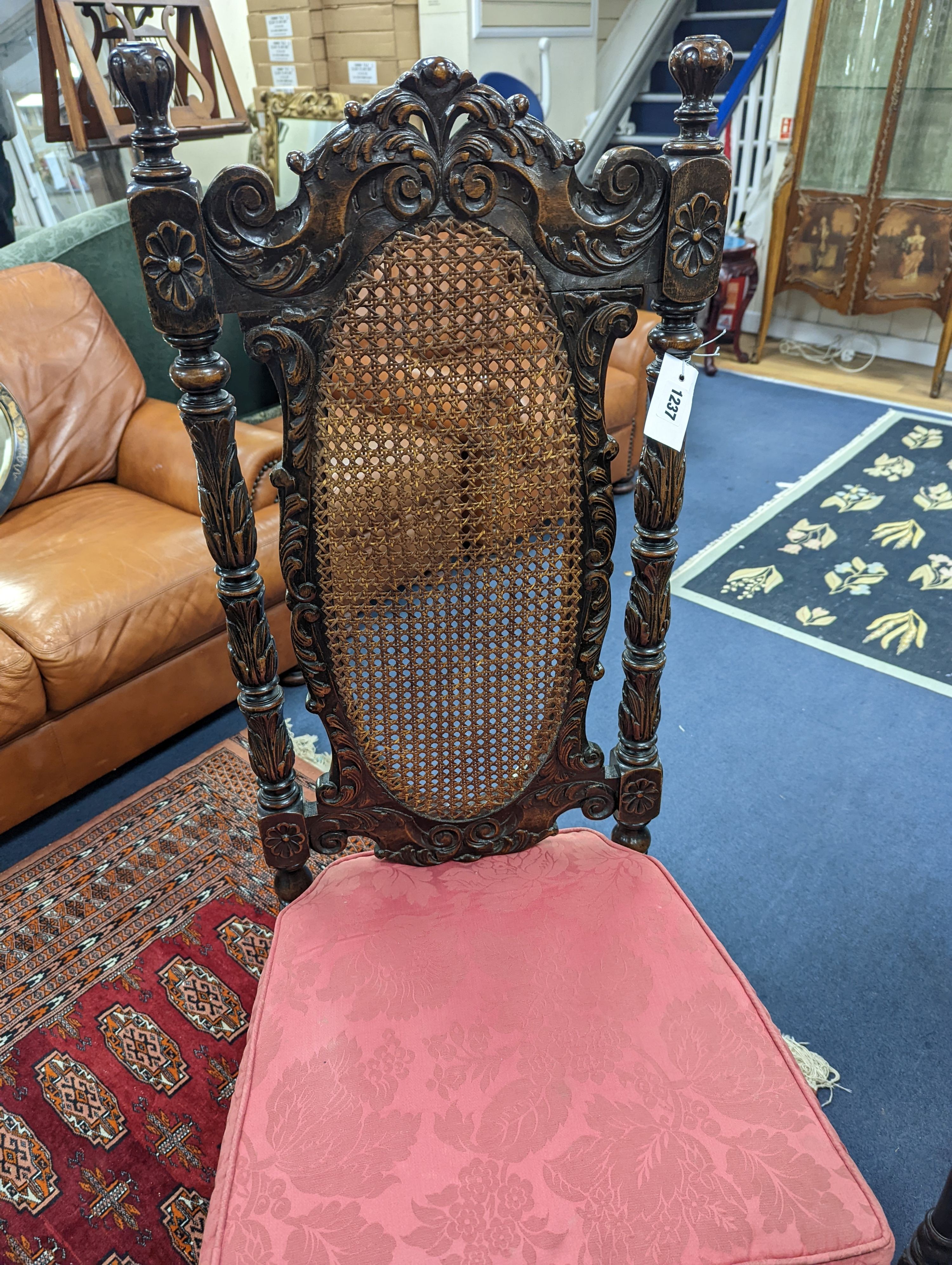 A set of six Charles II style carved oak dining room chairs with caned backs and seats and squab cushion seats